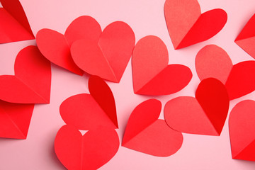 Small paper hearts on color background