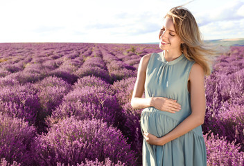 Pregnant woman in lavender field on summer day
