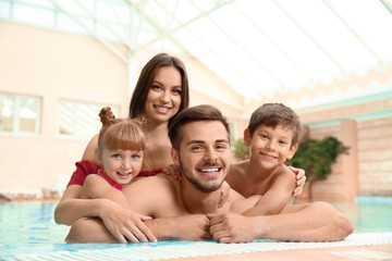 Happy family resting in indoor swimming pool