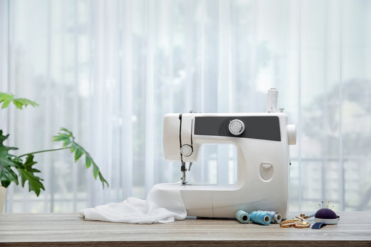 Sewing machine on table near window indoors
