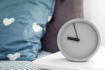 Fototapeta na wymiar Analog alarm clock on table in bedroom. Time of day