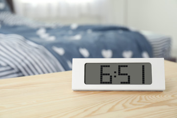 Digital alarm clock on table in bedroom. Time of day
