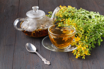 Transparent cup of green tea on wooden background