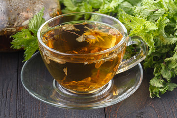 Transparent cup of green tea on wooden background