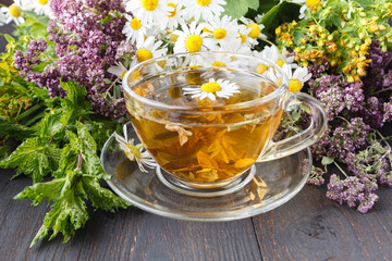 Transparent cup of green tea on wooden background