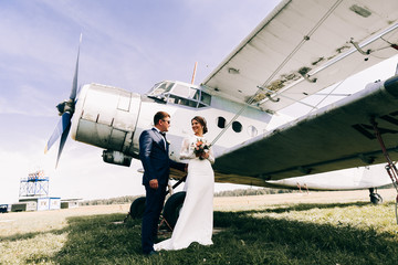 Newlyweds on a walk.Happy moments.Wedding photo shoot near the plane. Bride and groom, couple in...