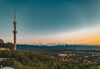 Fototapeta na wymiar Sunset over the city of Almaty and a view of the Kok Tobe TV Tower