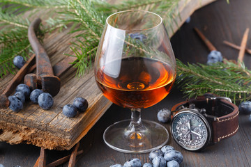 Glass and bottle of alcohol on wooden background