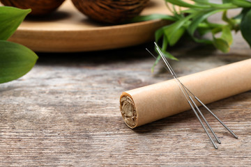 Moxa stick with needles for acupuncture on wooden table