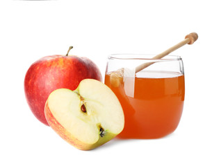 Glass jar with sweet honey and apples on white background