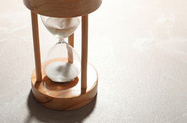 Hourglass with flowing sand on color background. Time management
