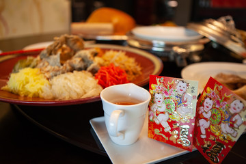 Yusheng or Prosperity Toss is a Cantonese-style raw fish salad. It is considered a symbol of abundance, a cultural activity dish for Chinese New Year. Chinese character on red envelop 