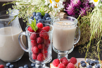 Overnight oats with fresh blueberries in jars on a rustic wood background