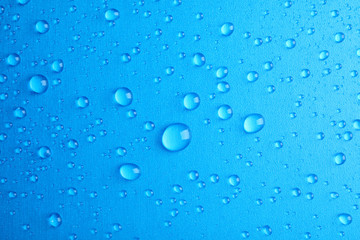 Many clean water drops on color background