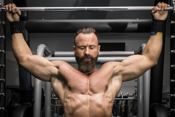 Fototapeta na wymiar Hombre fuerte con grandes músculos haciendo dominadas en el gimnasio. Ponerse en forma.