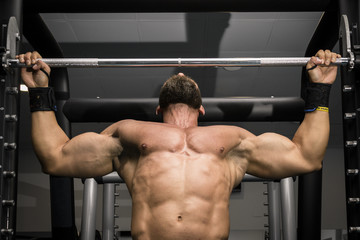 Hombre fuerte con grandes músculos haciendo dominadas en el gimnasio. Ponerse en forma.