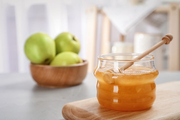 Jar of honey, apples and dipper on light table