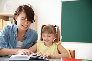 Female teacher helping child with assignment at school