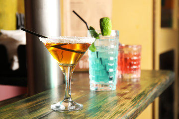 Glasses with delicious cocktails on counter in bar