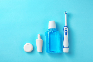 Flat lay composition with electric toothbrush and oral hygiene products on color background - obrazy, fototapety, plakaty