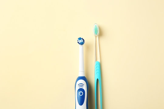 Manual and electric toothbrushes on color background. Dental care