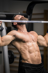 Fototapeta na wymiar Hombre fuerte con grandes músculos haciendo dominadas en el gimnasio. Ponerse en forma.