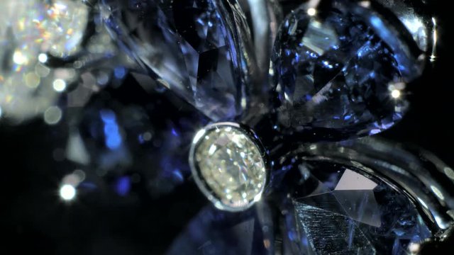 Closeup 4k shot of beautiful expensive and luxury jewel. Ring of the jewelry with dark blue sapphire and dimonds on the black background.