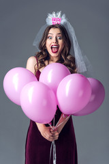 excited future bride in veil for bachelorette party holding bunch of pink air balloons isolated on...