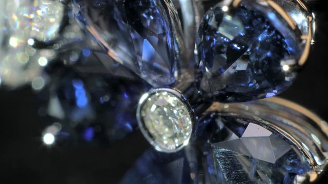 Closeup 4k shot of beautiful expensive and luxury jewel. Ring of the jewelry with dark blue sapphire and dimonds on the black background.