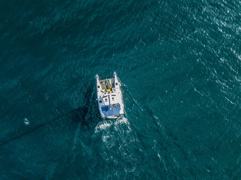 aerial top view from above of large sailing catamaran in the open sea isolated