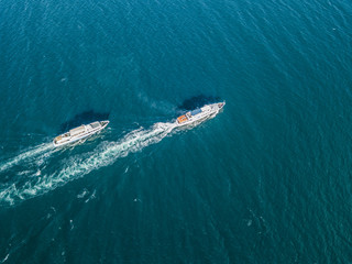 top view of two cruise ships in the open sea, one outrunning another