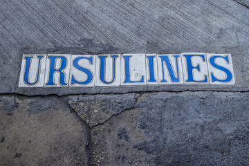 Closeup of the Street Name of Ursulines Avenue in Colorful Tiles in the Street’s Sidewalk Cement...