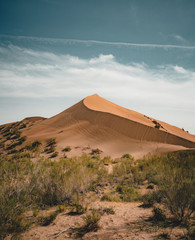 Fototapeta na wymiar Sand dunes under blue sky. Sahara Desert, Previously, village houses transferred due to sands movement.