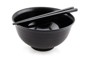 black bowl and chopsticks on white background
