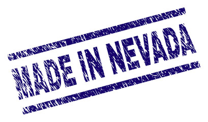 MADE IN NEVADA stamp seal watermark with grunge style. Blue vector rubber print of MADE IN NEVADA tag with retro texture. Text tag is placed between parallel lines.