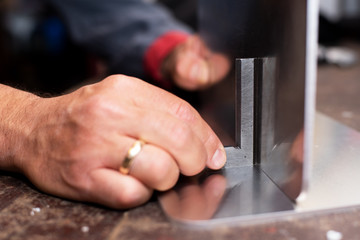 Handwerker misst Metallfläche