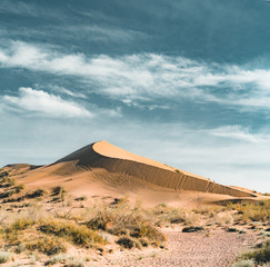 Sand dunes under blue sky. Sahara Desert, Previously, village houses transferred due to sands...