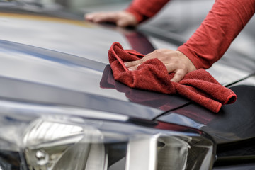 Ein Auto wird nach der Autowäsche mit einem Tuch poliert