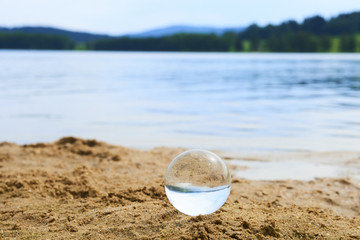 Fototapeta na wymiar Glass ball at the sand beach 