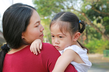 Mother carry her baby was crying in park.