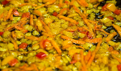 cooking a roast for soup of onions, carrots, paprika, tomatoes, herbs and spices in sunflower oil in a frying pan