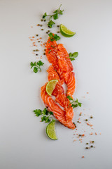 Fresh salmon slices and spices on white background