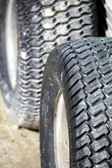 Fototapeta na wymiar Close up of two tyres or tires on sandy mud, showing tread detail, one in focus and one in out of focus background