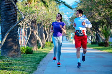 Urban sports, healthy young couple jogging in the city at sunny morning