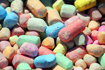Close up of several pieces of multi colored colourful chalk, red, blue, orange,yellow, green and pink