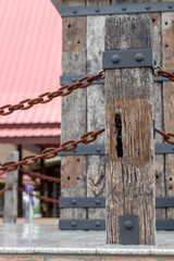 Old wooden pole with rusty chain rust.