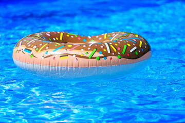 inflatable ring - donut in the blue water in the pool. travel, vacation, holidays in the summer concept