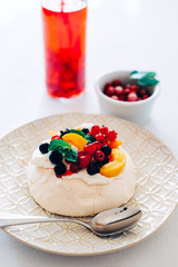 Tasty Pavlova dessert with white meringue, cream and fruit