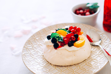 Tasty Pavlova dessert with white meringue, cream and fruit