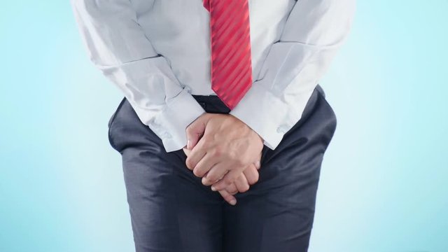 a person has problems with the genitourinary system. businessman on a colored background. 4k, close-up, slow-motion shooting.